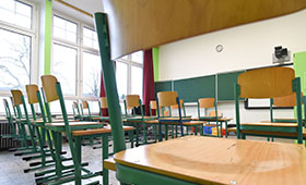 Blick in einen Klassenraum. Die Sthle sind hochgestellt.