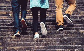 Drei junge Menschen gehen auf einer Treppe aufwrts