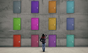 Jugendliche steht vor einer Wand mit mehreren verschiedenfarbigen Tren