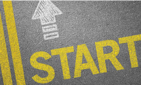 Auf einer grauen Strae ist in gelben Buchstaben "Start" zu lesen. Darber ein weier Pfeil.
