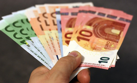 Eine Hand hlt aufgefcherte Euro-Scheine
