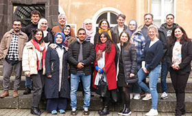 Eine Gruppe Menschen steht auf einer kleinen Treppe. Bild: TH K�ln