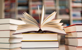 Drei Bcherstapel, ein aufgeklapptes Buch