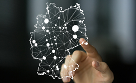 Datenbank Frderprogramme: Finger zeigt auf transparente Deutschlandkarte, darin durch Linien verbundene Punkte