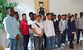 Eine Gruppe junger Menschen steht im Halbkreis. Eine Gruppe junger Menschen steht im Halbkreis.