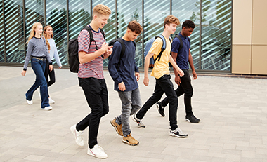 Eine Gruppe von Jugendlichen verlässt ein Schulgebäude Eine Gruppe von Jugendlichen verlässt ein Schulgebäude
