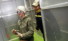 Schüler mit Dunkelbrille wird von Mitschüler durchs Labyrinth geführt Schüler mit Dunkelbrille wird von Mitschüler durchs Labyrinth geführt