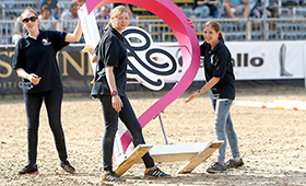 Junge Frauen tragen ein Gestell ins Reitstadion