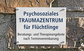 Schild: "Psychosoziales Traumazentrum für Flüchtlinge"