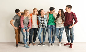 Eine Gruppe Jugendlicher steht zusammen vor einer Wand.