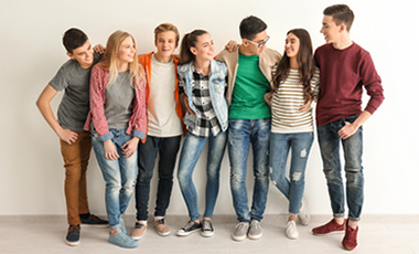 Eine Gruppe Jugendlicher steht zusammen vor einer Wand