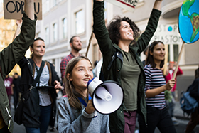 Mädchen mit Flüstertüte und weitere junge Menschen bei Demonstration gegen Klimapoltitik