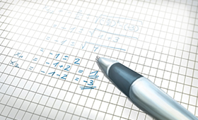 Kugelschreiber auf Heftseite mit mathematischen Gleichungen