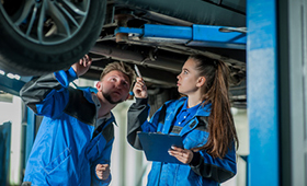 Auszubildende und Auszubildender in einer Autowerkstatt