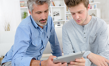 Vater und Sohn schauen auf ein Tablet Vater und Sohn schauen auf ein Tablet