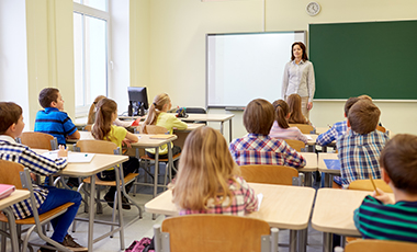 Eine Lehrerin unterrichtet mit Hilfe eines digitalen Tafelboards ihre Klasse Eine Lehrerin unterrichtet mit Hilfe eines digitalen Tafelboards ihre Klasse