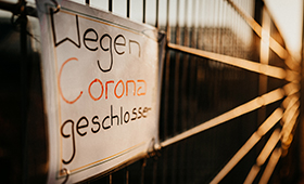 Schild an Betriebszaun: "Wegen Corona geschlossen"