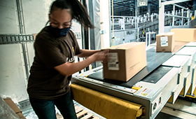 Junge Frau beim Verladen von Postpaketen