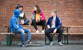 Vier Jugendliche sitzen zusammen und unterhalten sich