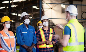 Ausbilder und Auszubildende in einem Industriebetrieb