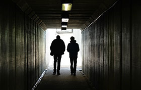 Zwei Jugendliche gehen in einem Tunnel dem Ausgang entgegen