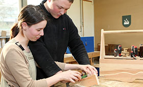 In der Holzwerkstatt arbeiten ein junger Mann und eine junge Frau an einer Werkbank. Bild: Vesbe e.V.