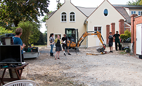 Baustelle mit Bagger und DarstellerInnen