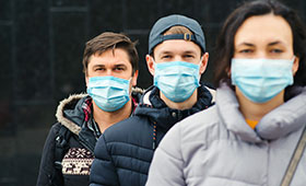Drei Jugendliche mit Mund-Nasen-Schutz, frontal zum Betrachter stehend