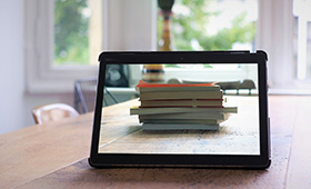 Tablet, das einen Stapel Bücher zeigt Tablet, das einen Stapel Bücher zeigt
