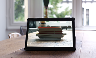 Tablet, das einen Stapel B�cher zeigt