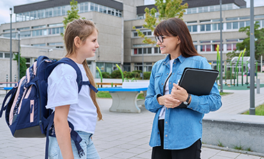 Eine Sch�lerin und eine Lehrerin im Gespr�ch auf dem Schulhof