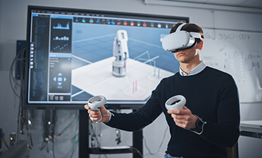 Junger Mann mit VR-Brille vor einem großen Monitor Junger Mann mit VR-Brille vor einem großen Monitor