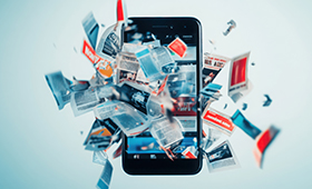 Ein Smartphone, durch dessen Oberflche eine groe Menge an Zeitungen und Zeitschriften mit Bildern und Schlagzeilen herausdringen