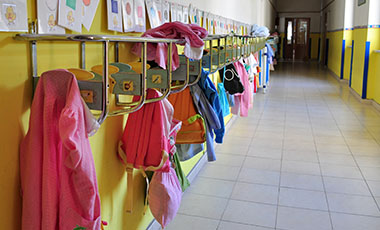 Flur in einem Kindergarten. An Haken h�ngt Kinderkleidung. Bild: Daniele Pietrobelli | Adobe Stock