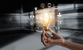 Eine H�nde h�lt eine Gl�hbirne, um die herum Symbole verschiedener Medienformate angeordnet sind