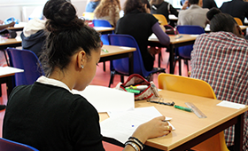 Eine Sch�lerin mit dunkler Hautfarbe, an ihrem Schultisch sitzend