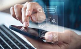 Eine Hand h�lt ein Smartphone, die andere tippt. Eingespiegelt eine Chatbot-Konversation.