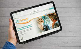 Eine Hand h�lt ein Tablet mit der aufgerufenen Startseite von �beraus