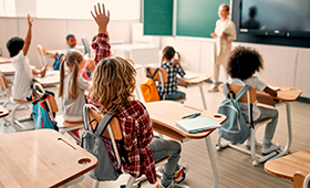 Junge Sch�lerinnen und Sch�ler in einem Klassenraum, einige heben eifrig die Arme