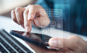 Eine Hand h�lt ein Smartphone, die andere tippt. Eingespielt eine Chatbot-Konversation.