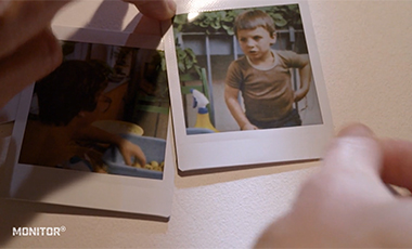 Eine Hand legt das Polaroid-Foto eines Jungen auf die Seiten eines Fotoalbums Eine Hand legt das Polaroid-Foto eines Jungen auf die Seiten eines Fotoalbums